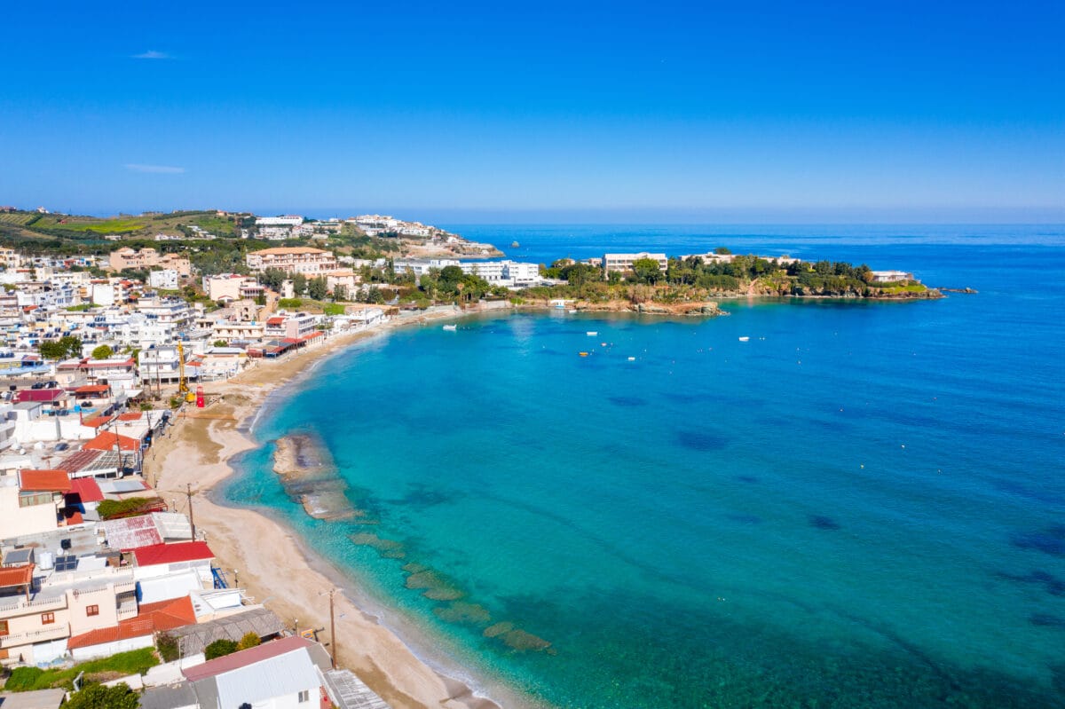 Agia Pelagia Beach Village in Crete with turquoise waters, whitewashed houses, and scenic coastline.